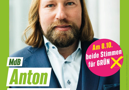 Plakat im grünen Rahmen mit Sonnenblume rechts oben, auf dem Toni Hofreiter den Betrachter direkt ansieht. Ein runderStörer rechts im Bild fordert dazu auf, bei der bayerischen Landtagswahl  am 08.10.2023 den Grünen beide Stimmen zu geben. Der Text unter Toni Hofreiters Bild kündigt  "MdL Anton Hofreiter vor Ort" am 21. Juli, 19:00 Uhr, Gasthaus zur Krone, Petersaurach" an 