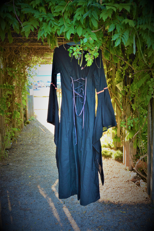 Kleid der Märchenerzählerin hängt unter dem Eingangslaube des Schaugartens und erzeugt geheimnisvolle Stimmung ©Uli Grüber